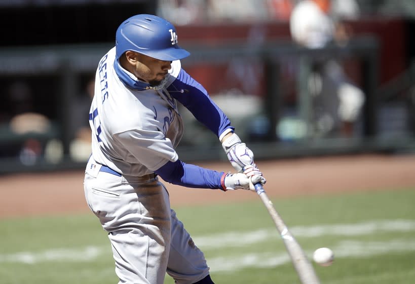 Los Angeles Dodgers' Mookie Betts singles in the sixth inning of the first game of a baseball doubleheader.