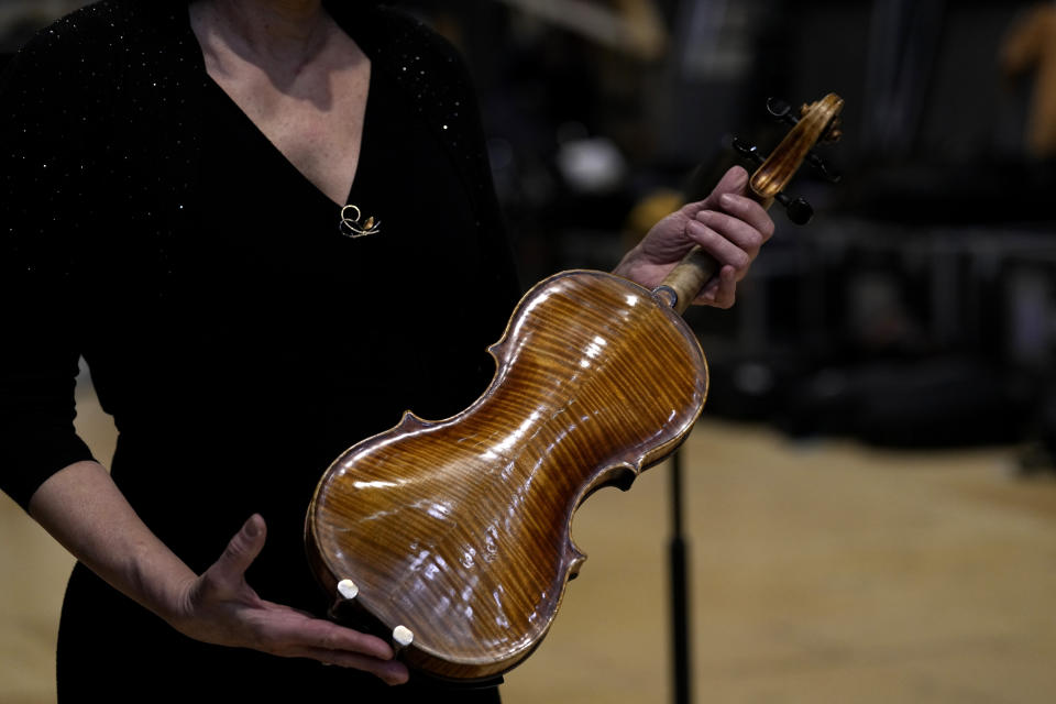 Principal Second Violin of the National Symphony Orchestra (NSO) Marissa Regni shows a violin, one of a rare Italian string instruments from the 17th and 18th century used for the concert, at the backstage of Milan's La Scala theatre, Italy, Monday, Feb. 26, 2024. (AP Photo/Antonio Calanni)