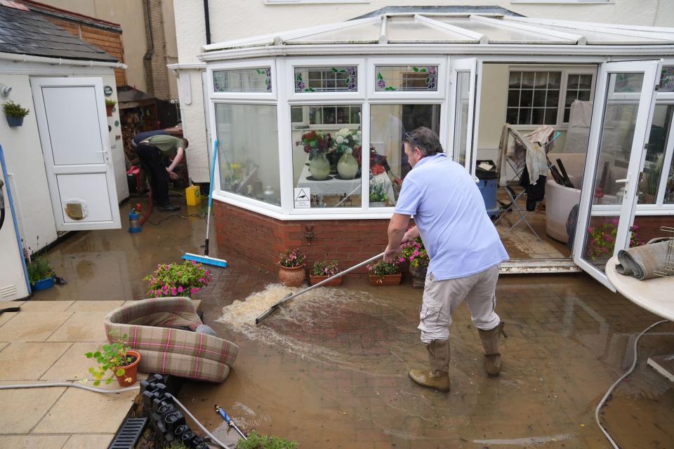 Neighbours help to clear flood water from the home of John Sayles in Grendon, Northamptonshire. An amber weather warning for heavy rain has come into force in parts of England, with the Met Office warning that affected areas could experience more than a month's worth of rain falling on Monday. Picture date: Monday September 23, 2024.