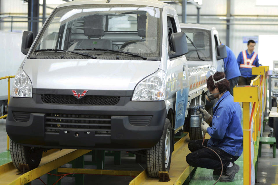 In this photo taken Wednesday April 16, 2014, workers put the finishing touch to a pickup at a factory of SGMW, a joint venture between Chinese carmakers and General Motors in Qingdao in east China's Shandong province. China’s automakers are the underdogs heading into next week’s Beijing auto show, where foreign and domestic brands will jostle for attention in a crowded market. Facing intense competition from General Motors, Volkswagen and other global rivals, local brands such as Chery, Geely and SUV maker Great Wall have seen sales and market share shrink this year while China’s overall market grew. (AP Photo) CHINA OUT
