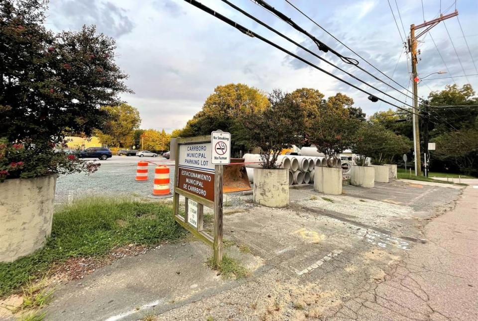 Construction equipment and concrete drainage pipes rest in a corner of the public parking lot at 203 S. Greensboro St. in Carrboro. The parking lot will be closed so that construction can start on a new Orange County library branch and town cultural center.