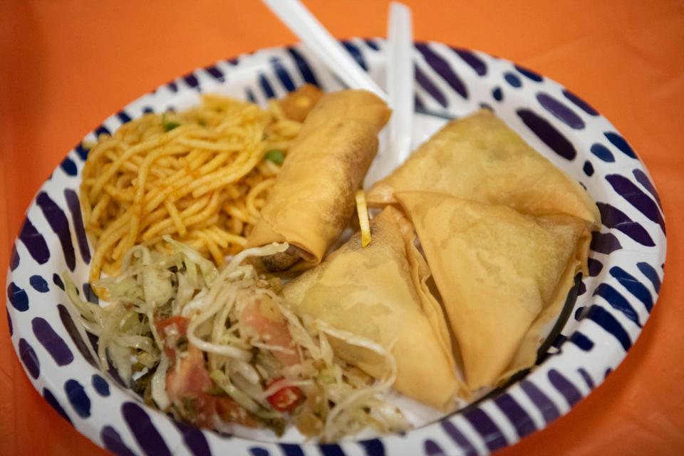 Students enjoy Mot-Te noodle salad and samosas during a youth multicultural exchange event at the Burma Center in Springfield, Michigan on Wednesday, April 27, 2022.