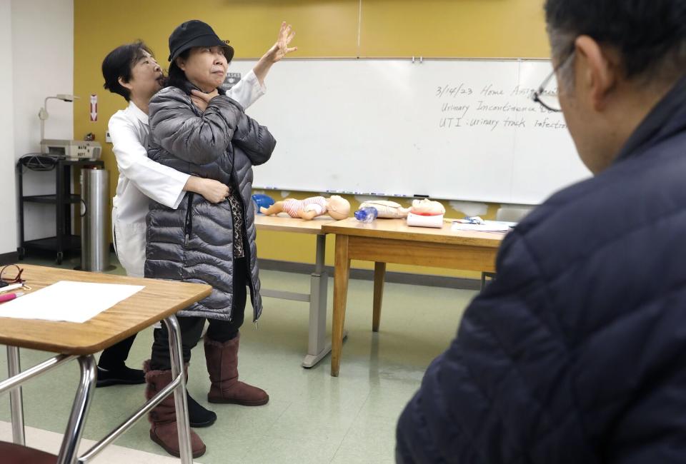 A professor simulates how to help a person who is choking.