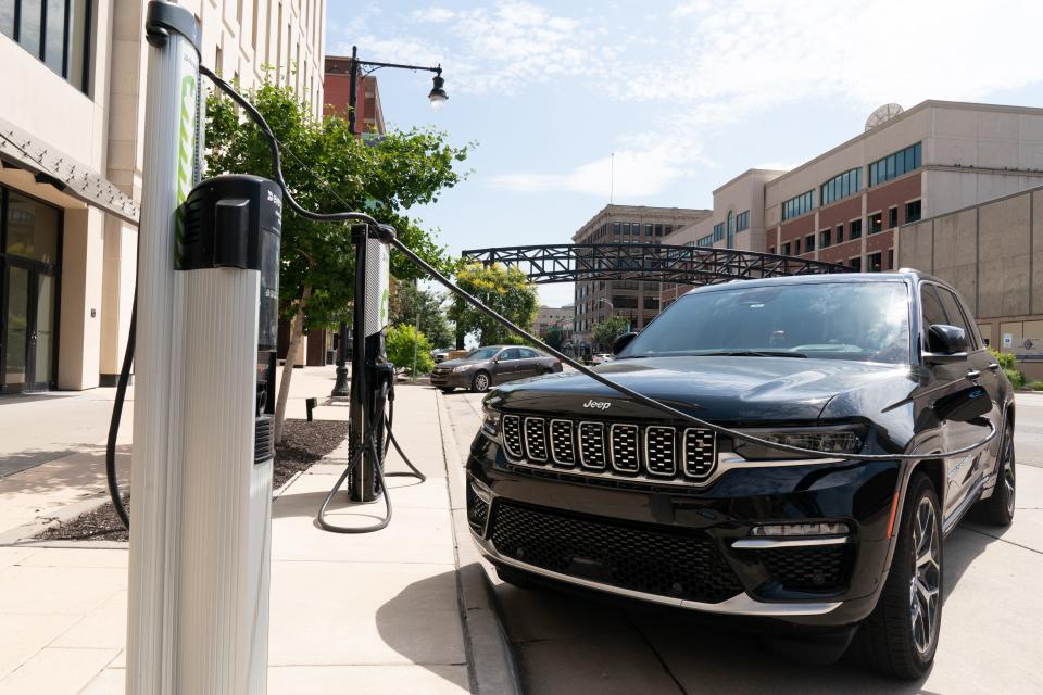 An electric Jeep Grand Cherokee is seen plugged in to a charging station outside of the Evergy building in downtown Topeka.