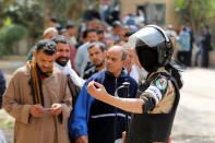 An army soldier gestures as people stand in line to cast their vote during the referendum on draft constitutional amendments, at a polling station in Cairo, Egypt April 20, 2019. REUTERS/Mohamed Abd El Ghany