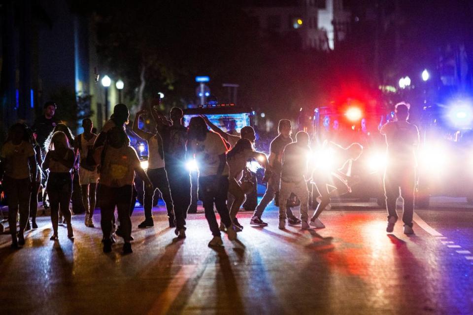 Crowds party in the street while a speaker blasts music an hour past curfew in Miami Beach, Florida, on Sunday, March 21, 2021. As Miami Beach Police closed down Ocean Drive, droves of people moved west toward Alton Road before a few arrests broke up the crowd.