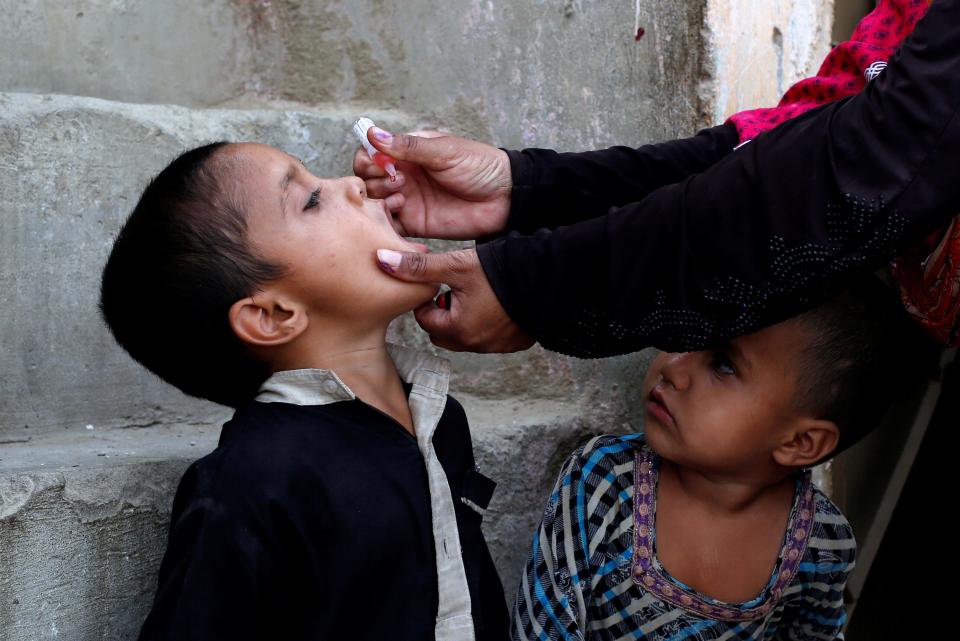 FILE PHOTO: A boy receives polio vaccine drops, during an anti-polio campaign, in a low-income neighbourhood in Karachi, Pakistan April 9, 2018. REUTERS/Akhtar Soomro