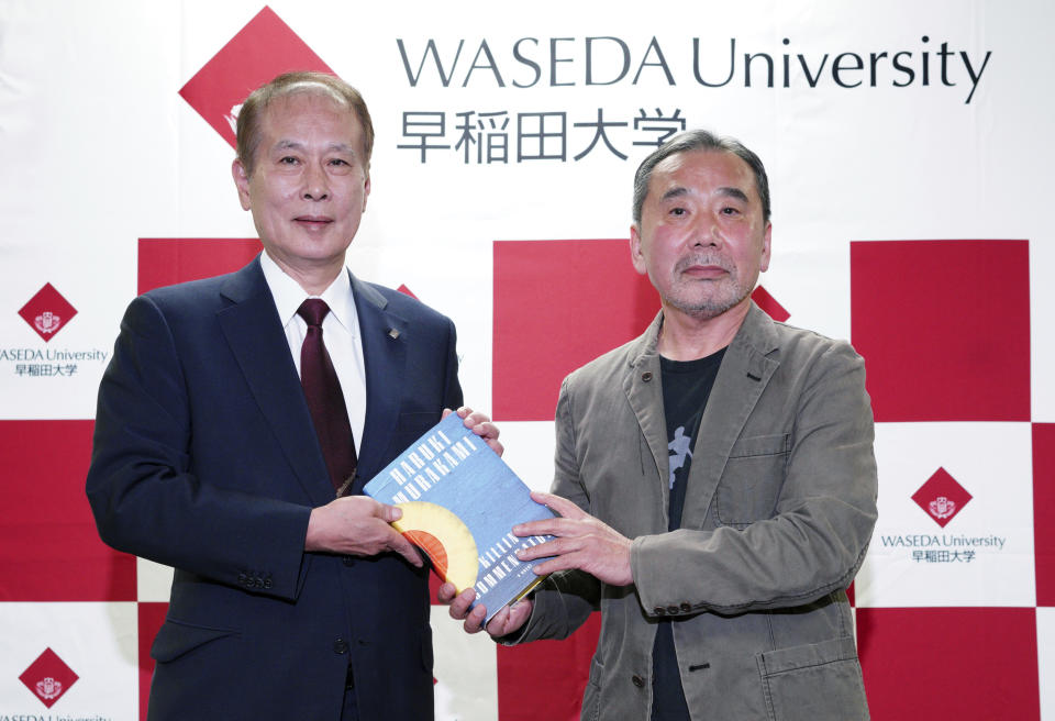 Japanese novelist Haruki Murakami, right, poses for photographers with Kaoru Kamata, left, Waseda's University President during a press conference at Waseda University in Tokyo Saturday, Nov. 3, 2018. (AP Photo/Eugene Hoshiko)
