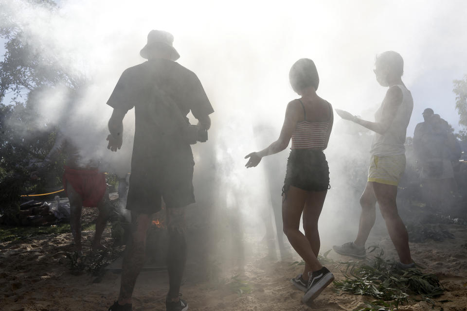 Members of the public participate in an Aboriginal smoking ceremony during Australia Day ceremonies in Sydney, Tuesday, Jan. 26, 2021. (AP Photo/Rick Rycroft)