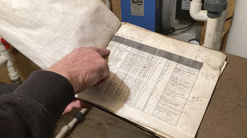 In this Jan. 4, 2022, photo Tim Maye holds a log sheet showing some of the maintenance visits for his water treatment system in Dimock, Pa. Maye says his system, designed to remove gas drilling-related contaminants from his well water, never seemed to work properly. Faulty gas wells drilled by Cabot Oil & Gas were blamed for leaking methane into the groundwater in Dimock, in one of the best-known pollution cases ever to emerge from the U.S. drilling and fracking boom. In 2010, the Pennsylvania Department of Environmental Protection negotiated a settlement with Cabot to install water treatment systems at residents' homes, but some say the systems did not work well. (AP Photo/Mike Rubinkam)