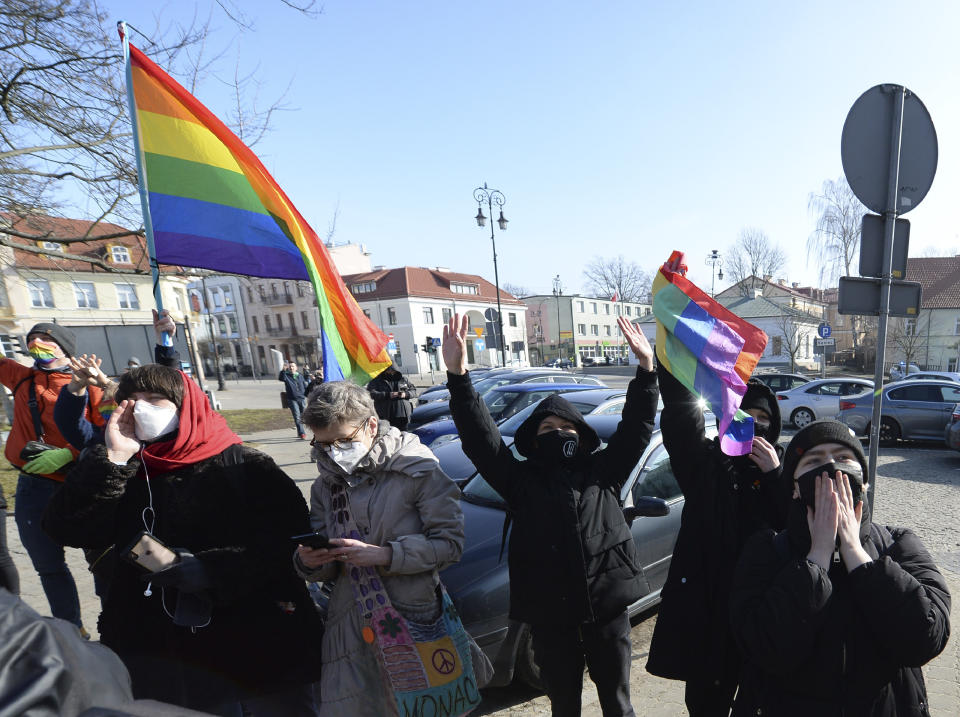 Polish LGBT rights activists gather outside a court which acquitted three women who faced trial on accusations of desecration, in Plock, Poland, Tuesday March 2, 2021. A Polish court has acquitted three activists who had been accused of desecration for adding the LGBT rainbow to images of a revered Roman Catholic icon. In posters that they put up in protest in their city of Plock, the activists used the rainbow in place of halos on a revered image of the Virgin Mary and baby Jesus. (AP Photo/Czarek Sokolowski)