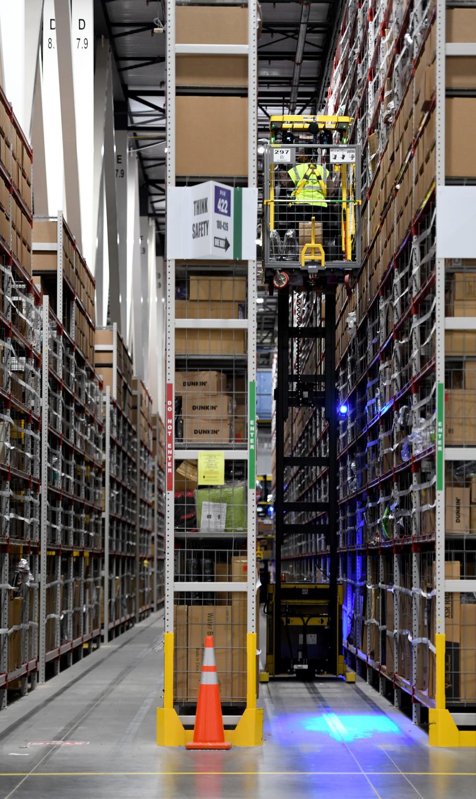 An emplyoyee collects items for an order at the Amazon facility in Canton.