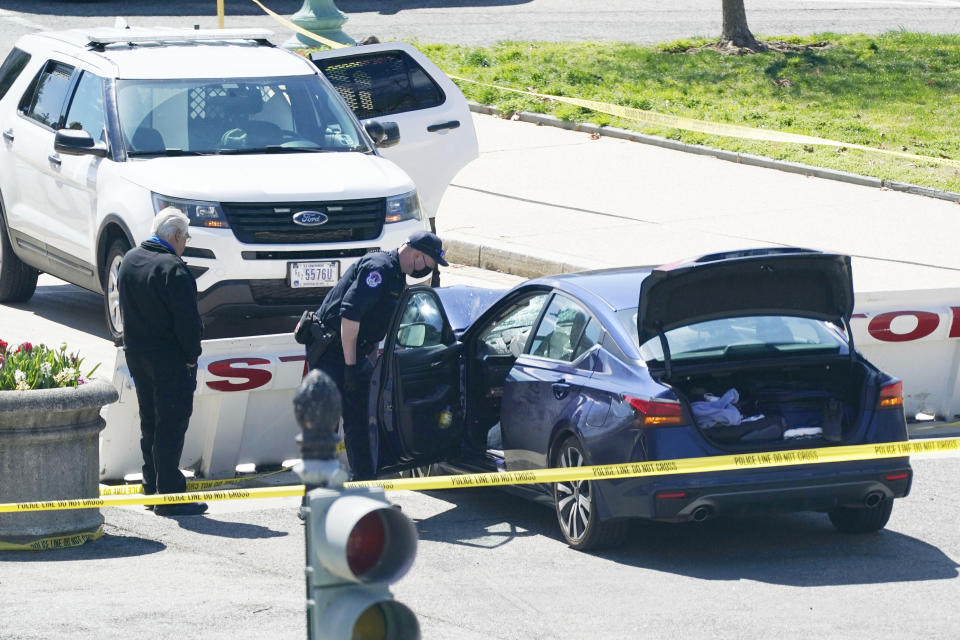 U.S. Capitol Police officers stand near a car that crashed into a barrier on Capitol Hill in Washington, Friday, April 2, 2021. (AP Photo/J. Scott Applewhite)