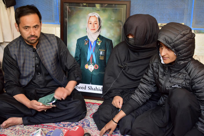 Sister Sadia Raza, center, relative Naimatullah Hazara, left, and friend Sumiaya Kianat, right, of female field hockey player Shahida Raza, who died in the shipwreck tragedy, attend her funeral, in Quetta, Pakistan, Friday, March 17, 2023. Raza was among other migrants who died in a shipwreck off Italy's southern coast. The migrants' wooden boat, crammed with passengers who paid smugglers for the voyage from Turkey, broke apart in rough water just off a beach in Calabria. (AP Photo/Arshad Butt)
