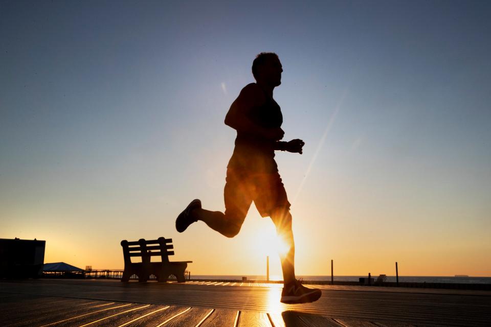 Early morning jogger runs on the boardwalk. Belmar: NJ Shore Towns, the best photos from sunrise to Last Call