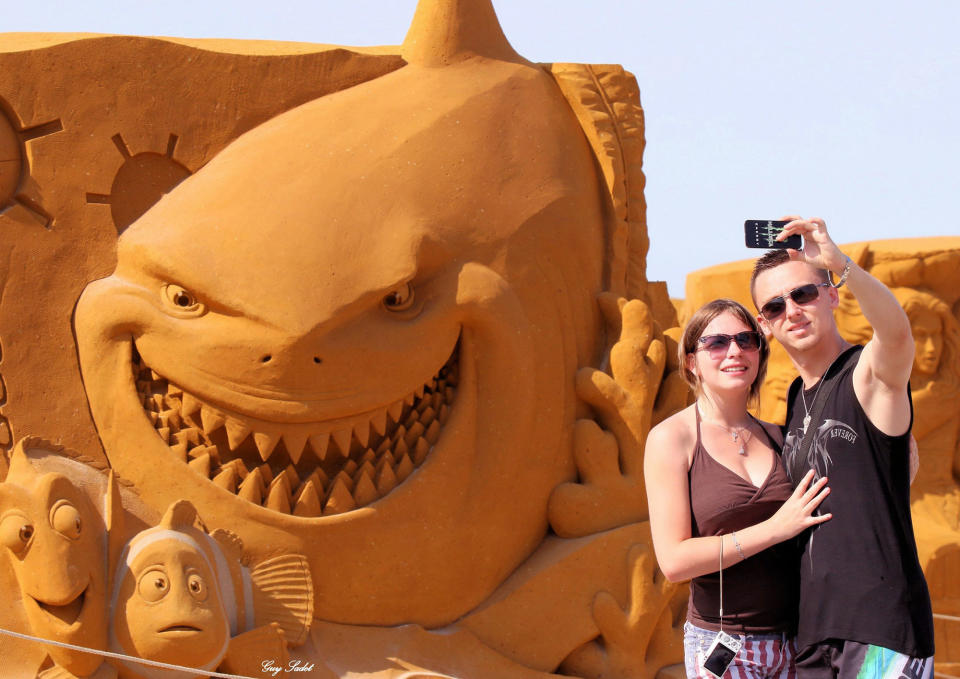 <p>Visitors pose next to a sculpture during the Sand Sculpture Festival “Disney Sand Magic” in Ostend, Belgium. (Photo courtesy of Disneyland Paris) </p>