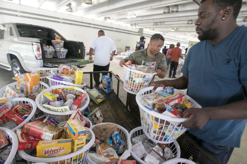 Volunteers unload baskets of food from a trailer brought by Showers of Blessing Harvest Center. A proposed city "Zero Waste" law would require restaurants and grocery stores to either donate food to pantries for the needy or compost it.