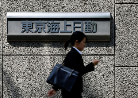 A woman walks past a sign of Tokio Marine & Nichido Fire Insurance Co at the company's headquarters in Tokyo, Japan, May 19, 2016. REUTERS/Toru Hanai