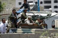 Shiite Huthi rebels sit in a pick-up truck mounted with a machine-gun in southern Sanaa, on April 21, 2015