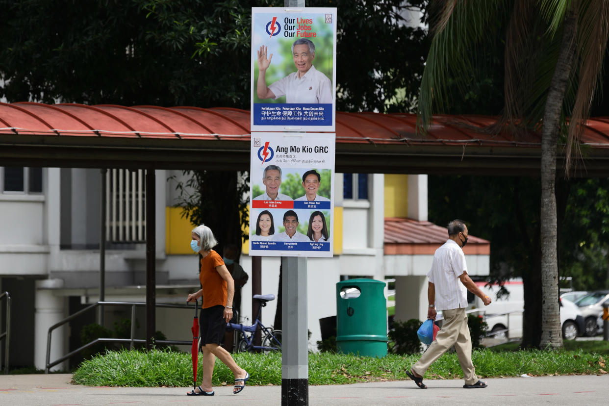SINGAPORE - JUNE 30:  People walk past a People's Action Party poster along the street on June 30, 2020 in Singapore. Singapore will go to the polls on July 10 as the ruling party, People's Action Party seeks a fresh mandate amid the coronavirus (COVID-19) pandemic. As of June 29, the total number of COVID-19 cases in the country stands at 43,361.  (Photo by Suhaimi Abdullah/Getty Images)