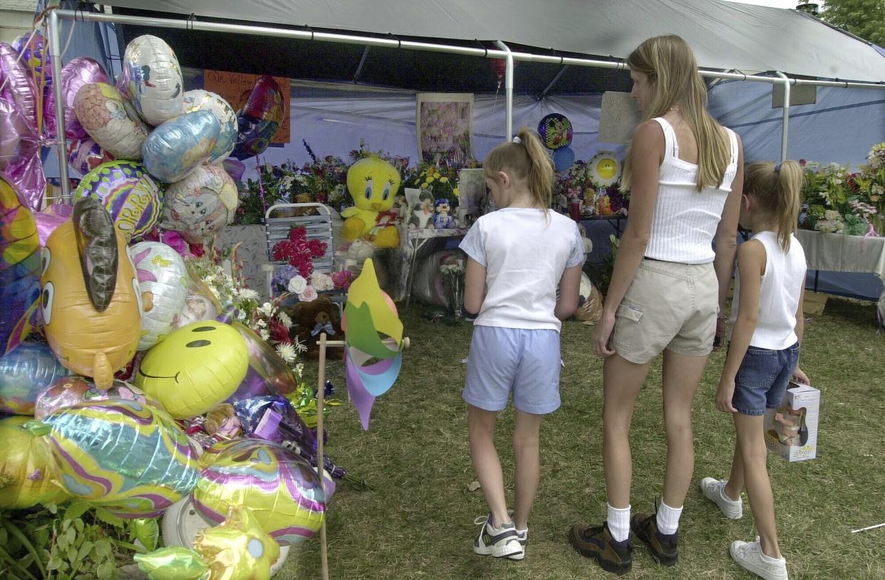 People look at the makeshift memorial in front of the home of Cassandra ''Casey'' Williamson, July 29, 2002, in Valley Park, Mo. (AP Photo/Diane L. Wilson)