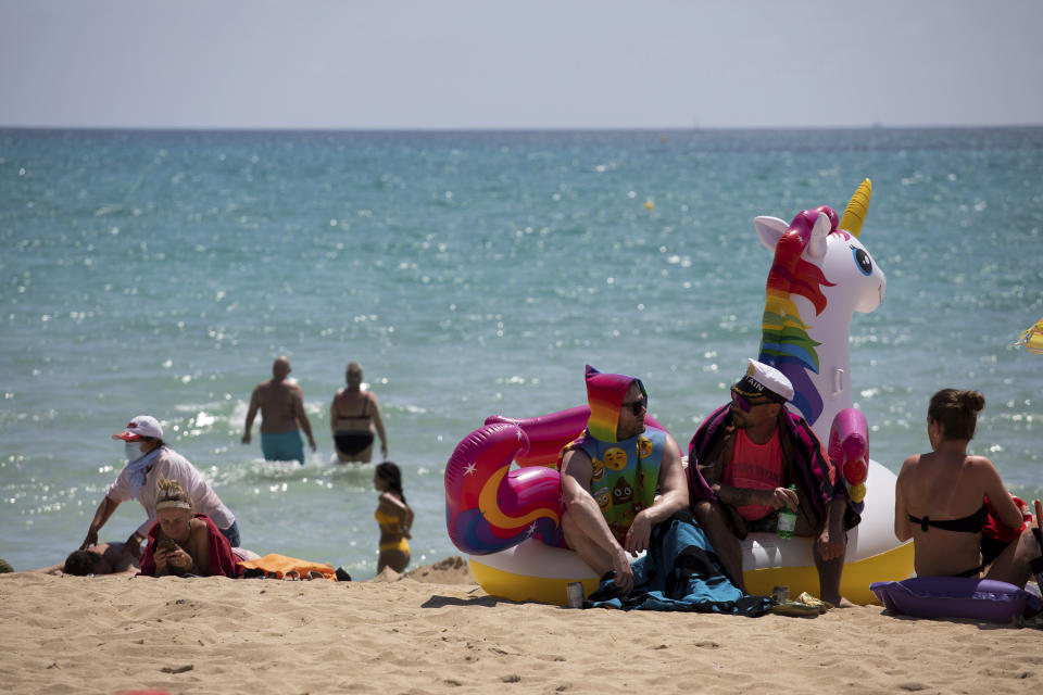 FILE - In this Monday, June 7, 2021 file photo, tourists sunbathe on the beach at the Spanish Balearic Island of Mallorca, Spain. Europe is opening up to Americans and other visitors after more than a year of COVID-induced restrictions. European governments hope to lure back tourists - and their dollars - back to the continent’s trattorias, vistas and cultural treasures. (AP Photo/Francisco Ubilla, FIle)