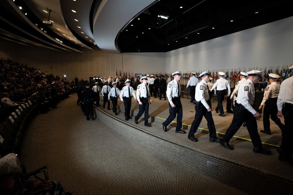 Officers walk in line to the stage at the start of the swearing-in ceremony for the 138th graduating class at the James G. Jackson Columbus Police Academy.