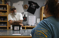 In this photo taken Tuesday, June 11, 2019, Chris Puehse, left owner of Foothill Ammo helps a customer at his shop in Shingle Springs, Calif. Californians will have to undergo criminal background checks every time they buy ammunition starting July 1 under a 2016 voter-approved ballot initiative. (AP Photo/Rich Pedroncelli)