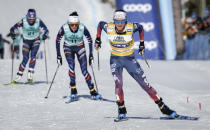 Jessie Diggins, right, of the United States, crosses the finish line to win the women's 15km Mass Start freestyle World Cup cross country skiing event in Canmore, Alberta, Friday, Feb. 9, 2024. (Jeff McIntosh/The Canadian Press via AP)
