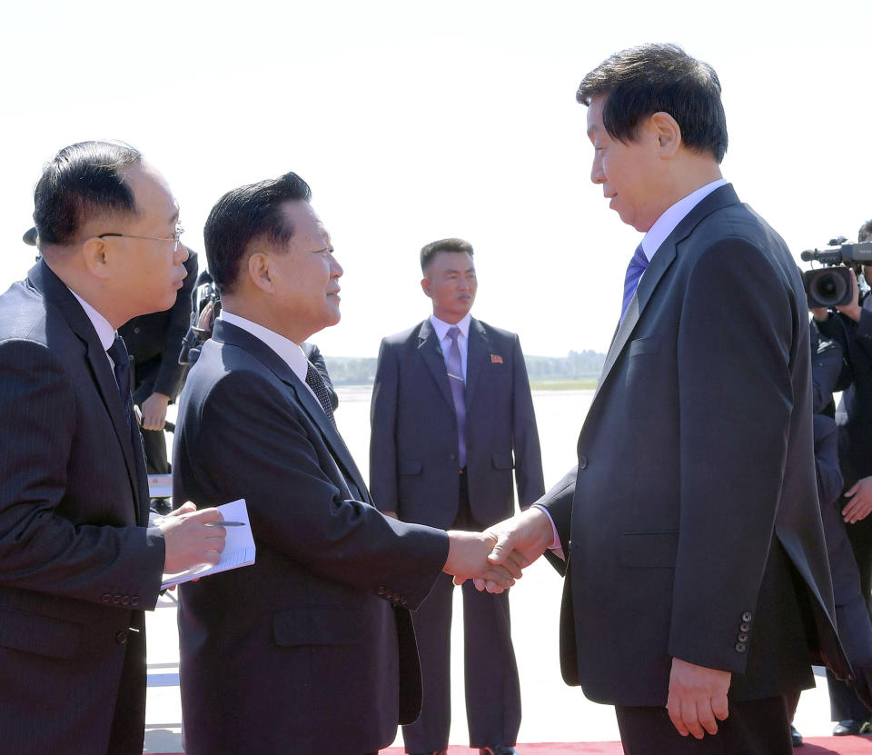 Senior Chinese official Li Zhanshu, right, is welcomed by Choe Ryong Hae, second from left, vice-chairman of the Central Committee of North Korea's ruling Workers' Party, upon arrival at Pyongyang International Airport in Pyongyang, North Korea Saturday, Sept. 8, 2018. Li, the Chinese ruling party's third highest official, will attend a big military parade on the 70th anniversary of North Korea's founding on Sunday, Sept. 9. (Kyodo News via AP)