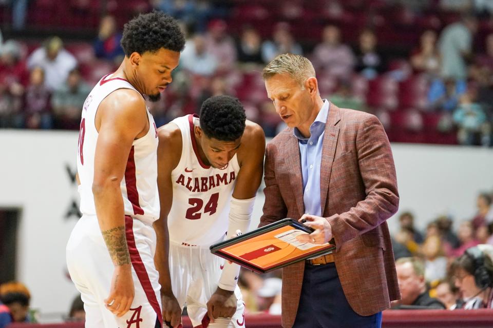 Nate Oats talks to forward Brandon Miller (24) and guard Dominick Welch. Oats has the overall No. 1 seed Crimson Tide chasing its first men's basketball national title.