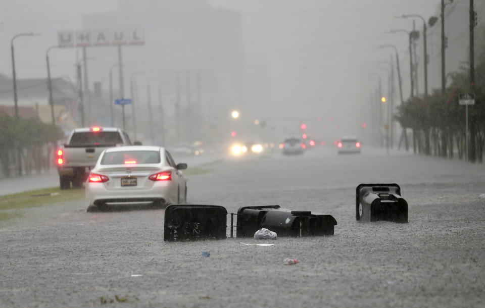 Vehicles head down a flooded Tulane Ave. as heavy rain falls Wednesday, July 10, 2019, in New Orleans. (David Grunfeld/The Advocate via AP)