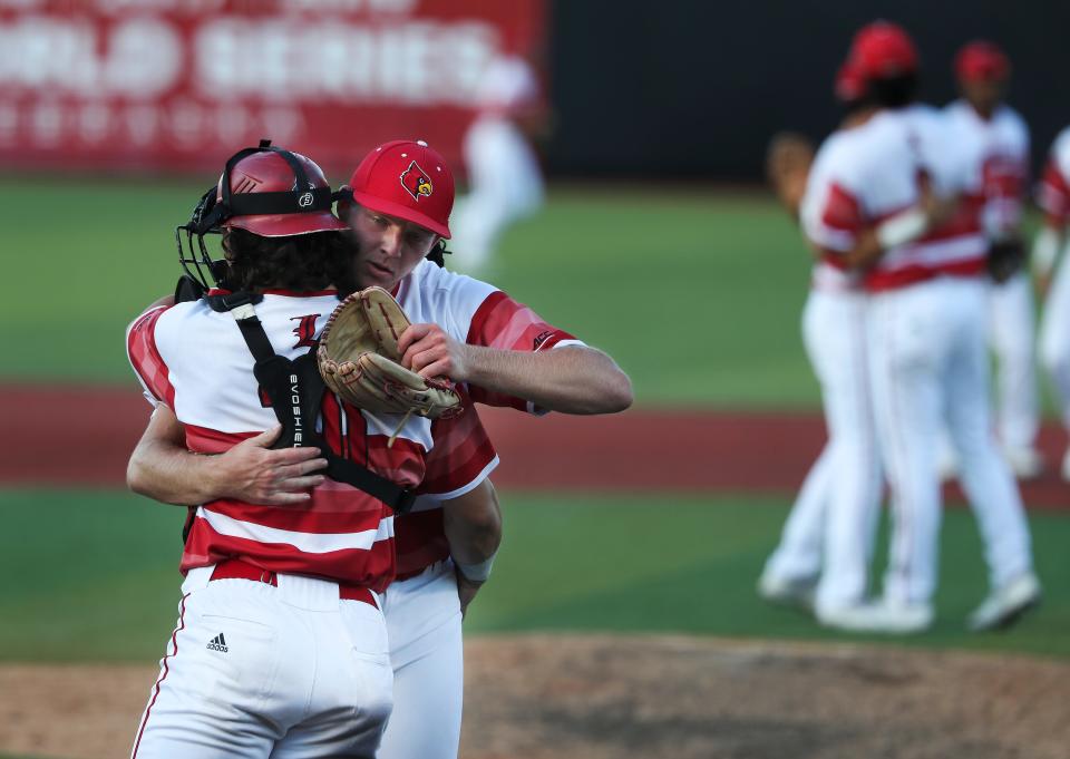 U of L pitcher Evan Webster (27), right, embraced catcher Dalton Rushing (20) after closing out the 9th inning against Michigan on Sunday during NCAA Regional play at Jim Patterson Stadium in Louisville, Ky. on June 5, 2022.  U of L won 20-1.