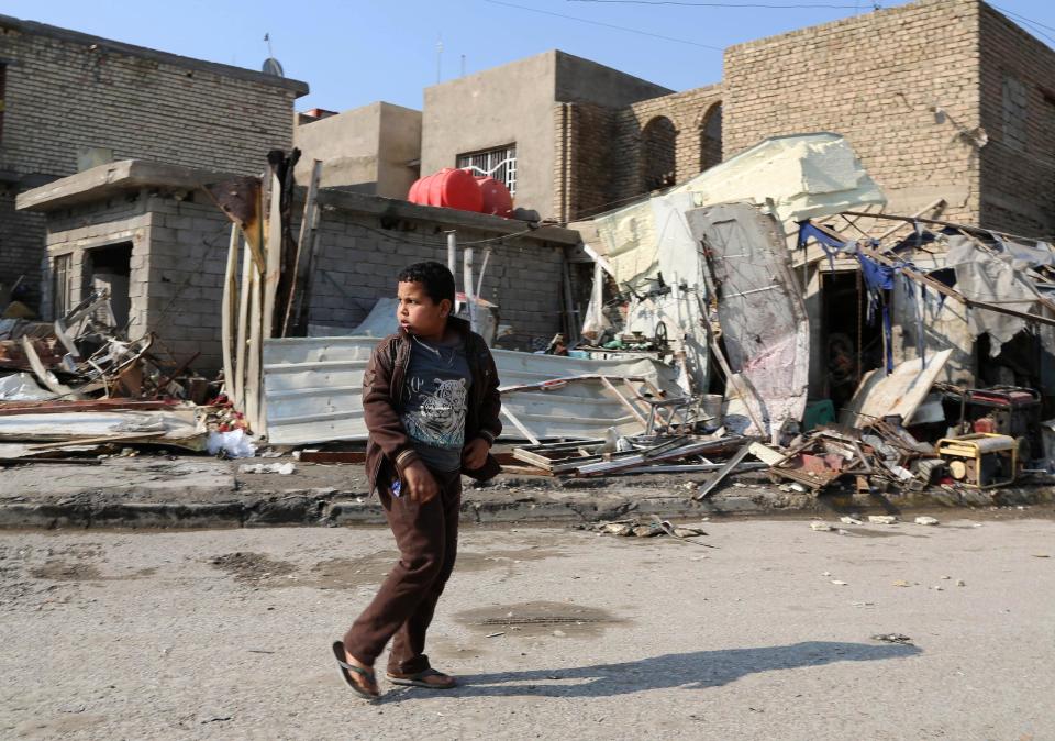 A boy walks amid rubble a day after a bombing in the Abu Disher neighborhood of southern Baghdad, Iraq, Tuesday, Jan. 21, 2014. Violence spiked in Iraq after the government staged a deadly crackdown on a Sunni protest camp last April. Militants have also targeted civilians, particularly in Shiite areas of Baghdad, with coordinated car bombings and other deadly attacks. (AP Photo/Karim Kadim)