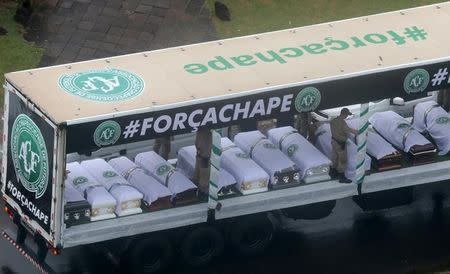 Coffins containing the remains of the victims of the plane crash in Colombia are loaded in a truck after paying tribute to them at Arena Conda stadium in Chapeco, Brazil, December 3, 2016. REUTERS/Diego Vara