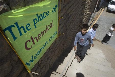 A boy walks past a placard which shows the place of an Iraqi chemical attack during the 1980-1988 war against Iran, in Nowdesheh in Kermanshah province 680 km (425 miles) south west of Tehran July 5, 2008. REUTERS/Morteza Nikoubazl