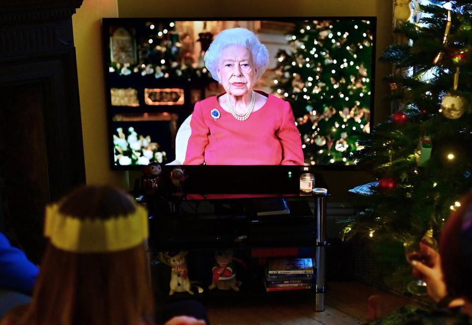 A family watch as Britain's Queen Elizabeth II delivers her annual Christmas Broadcast message, at their home near Liverpool on December 25, 2021