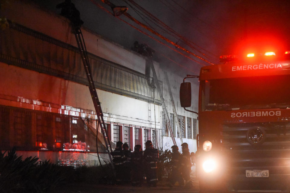 Firefighters work to control a fire at a warehouse owned by the national film institute, Cinemateca, which houses South America's largest collection of films, in Sao Paulo, Brazil, Thursday, July 29, 2021. Sao Paulo’s fire department said 15 fire vehicles and 50 firefighters were at the site working to prevent the flames from spreading to a larger area of the building. (Ronaldo Silva/Futura Press via AP)