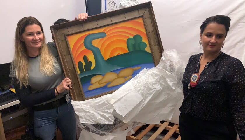 En esta foto difundida por la Policía de Río de Janeiro, agentes muestran la obra "Sol Poente", de Tarsila do Amaral, confiscada en una operación policial, el 10 de agosto del 2022. El cuadro es uno de 16 obras de arte valoradas en 139 millones de dólares y que fueron robadas a una viuda. (Foto, Policía de Río de Janeiro vía AP)