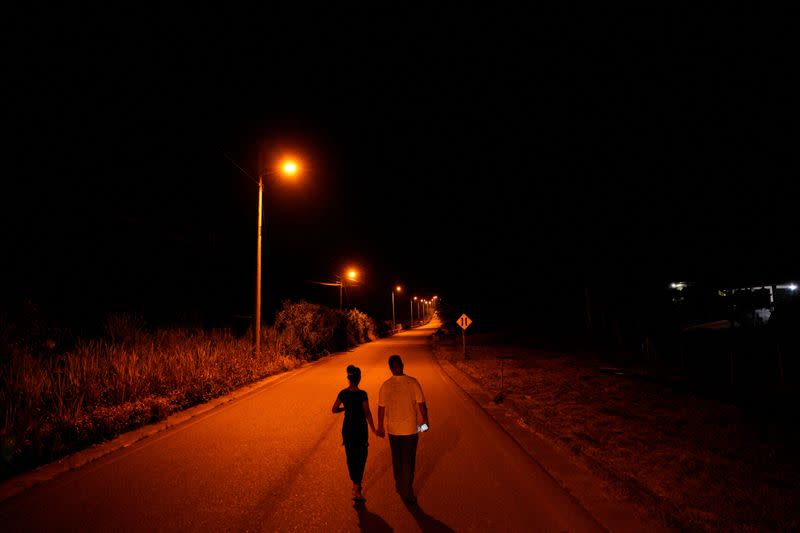 People walk next to state-owned oil company Petroecuador's plant in Lago Agrio