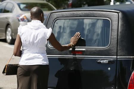 A mourner touches the hearse containing the casket of Alexander J. "AJ" Boik after Boik's funeral in Aurora, Colorado July 27, 2012. REUTERS/Rick Wilking