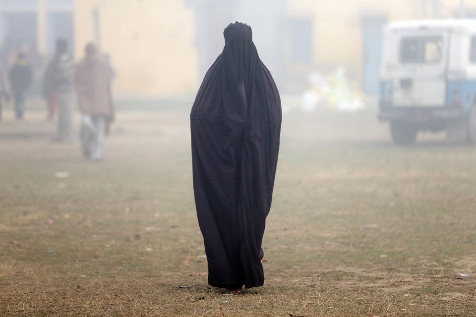 A woman wearing a burka leaves a polling booth in India