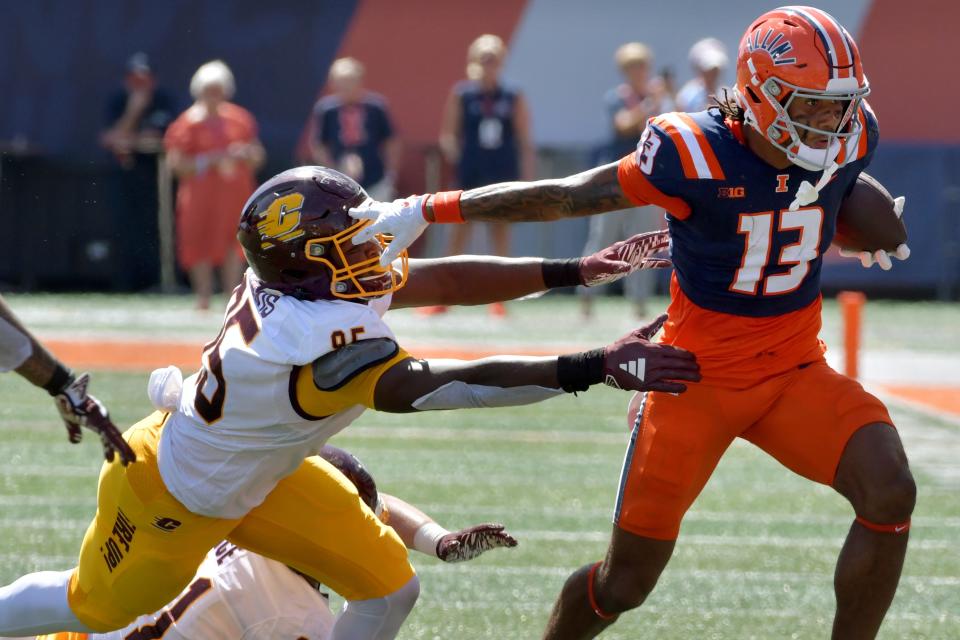 Sep 14, 2024; Champaign, Illinois, USA; Illinois Fighting Illini wide receiver Pat Bryant (13) stiff arms Central Michigan Chippewas defensive lineman Jaden Davis (95) during the first half at Memorial Stadium. Mandatory Credit: Ron Johnson-Imagn Images