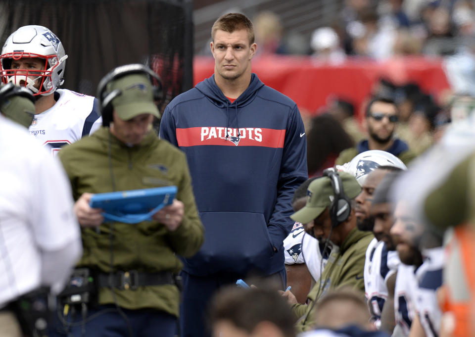 Injured New England Patriots tight end Rob Gronkowski, center, watches from the sideline in the first half of an NFL football game against the Tennessee Titans Sunday, Nov. 11, 2018, in Nashville, Tenn. (AP Photo/Mark Zaleski)