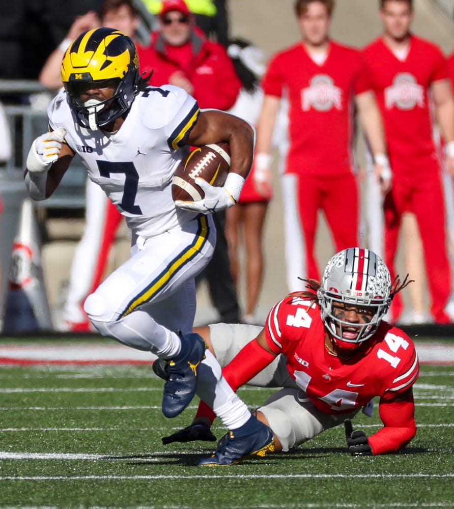 Michigan Wolverines running back Donovan Edwards (7) runs by Ohio State Buckeyes safety Ronnie Hickman (14) during first half action at Ohio Stadium in Columbus Saturday, November 26, 2022.