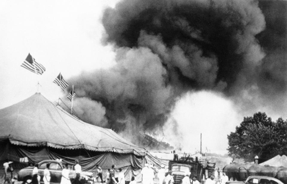 FILE - In this July 6, 1944 file photo people flee a fire in the big top of the Ringling Brothers and Barnum and Bailey Circus in Hartford. Conn. Authorities are exhuming the bodies of two victims of the 1944 circus fire in hopes of identifying a Vermont woman who has been missing since then. The exhumations began Monday morning, Oct. 7, 2019, at the Northwood Cemetery in Windsor, Conn. Officials will analyze DNA samples to determine whether one of the buried women is Grace Fifield of Newport, Vt. (AP Photo/File)