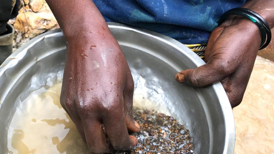 Eine Frau wäscht in der Mine Zola Zola bei Nzibira in der ostkongolesischen Provinz Süd-Kivu auf der Suche nach wertvollen Mineralien Gestein aus. Über weltweite Lieferketten gelangen sie in Handys und Autos.