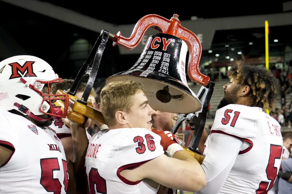 Miami RedHawks hoist the Victory Bell in the air after winning their football game against the rival Cincinnati Bearcats in overtime 31-24 Sept. 16, 2023 at Nippert Stadium.