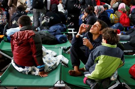 A boy blows soap bubbles at a migrant registration centre in Passau, Germany, October 8, 2015. REUTERS/Michaela Rehle