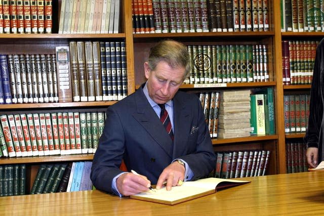 Charles signing a visitors' book